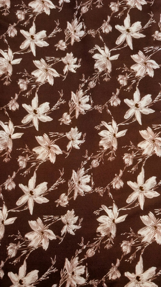 Brown fabric with a repeating floral pattern in a light beige or cream tone.