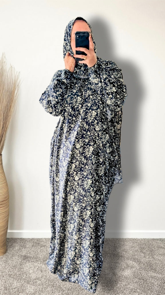 Navy floral botanical print prayer abaya with matching hijab on plain studio background