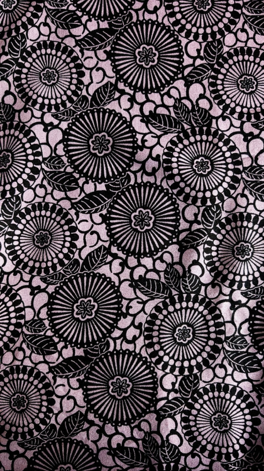Black mandala print pattern on a purple background