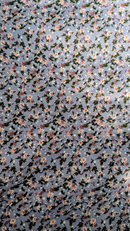 Floral patterned fabric with small flowers on a sky blue background