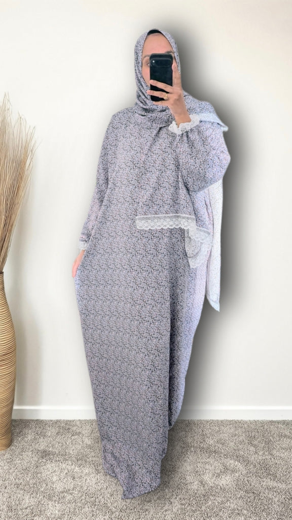 Muslim women wearing sky blue blossom floral print prayer abaya with matching hijab on plain studio background