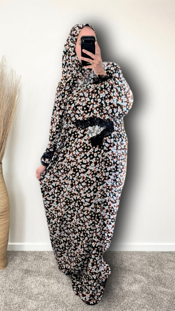 Muslim women wearing Black Daisy Floral print prayer abaya with matching hijab on plain studio background