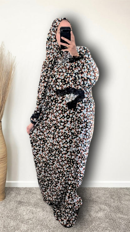 Muslim women wearing Black Daisy Floral print prayer abaya with matching hijab on plain studio background