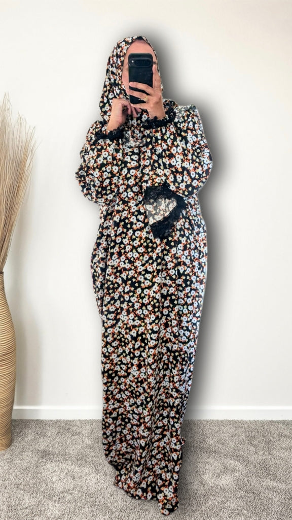 Muslim women wearing Black Daisy Floral print prayer abaya with matching hijab on plain studio background