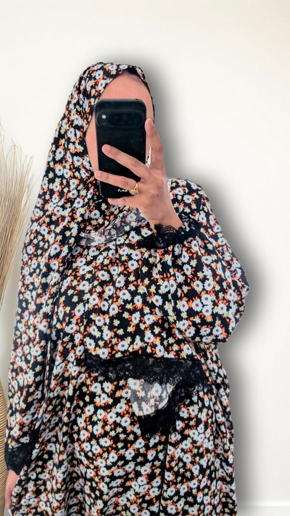 Muslim women wearing Black Daisy Floral print prayer abaya with matching hijab on plain studio background