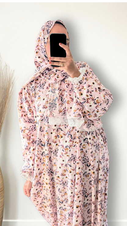 Muslim women wearing blush pink with meadow floral  print prayer abaya with matching hijab on plain studio background