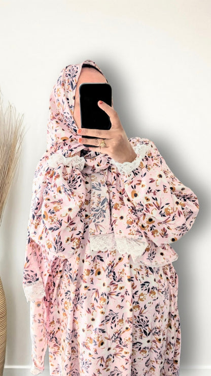 Muslim women wearing blush pink with meadow floral  print prayer abaya with matching hijab on plain studio background