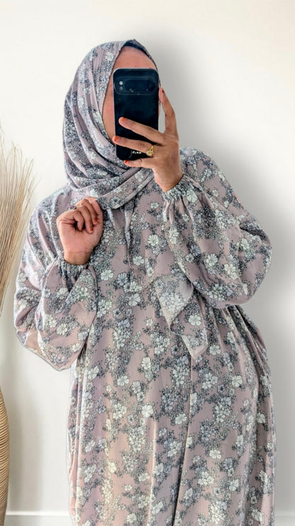 Muslim women wearing dusty mauve floral print prayer abaya with matching hijab on plain studio background
