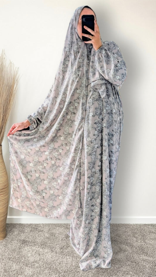 Muslim women wearing dusty mauve floral print prayer abaya with matching hijab on plain studio background