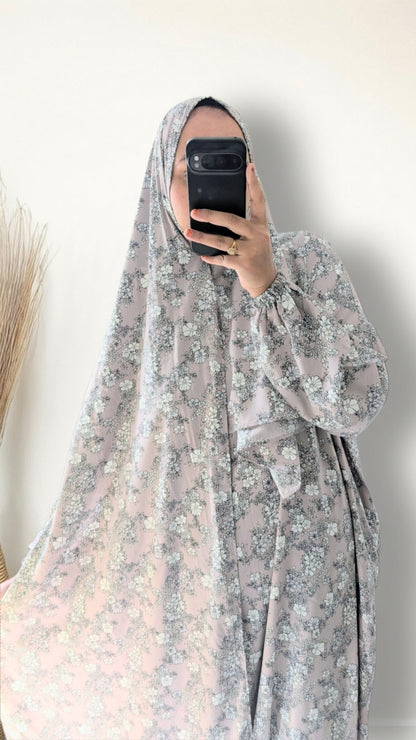 Muslim women wearing dusty mauve floral print prayer abaya with matching hijab on plain studio background