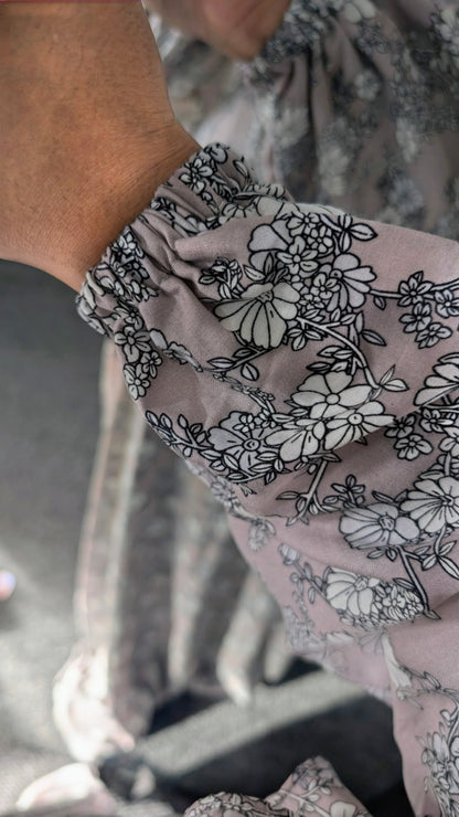 Close-up of elastic cuffed sleeve with dusty mauve , purplsh and pinkish floral pattern 