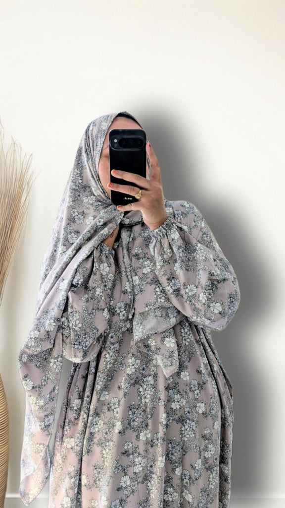 Muslim women wearing dusty mauve floral print prayer abaya with matching hijab on plain studio background