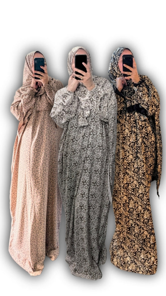 Three floral modest abayas with matching hijabs in beige, brown, and black on a white studio background