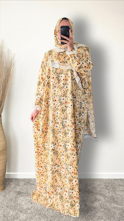 Yellow honey meadow floral print prayer abaya with matching hijab on plain studio background