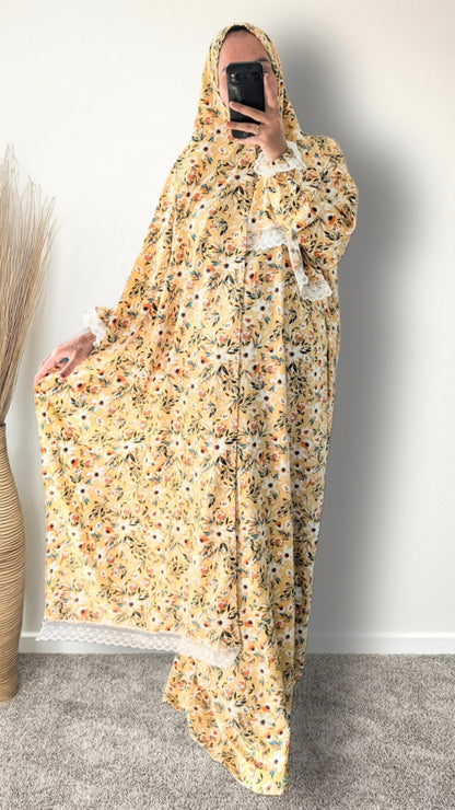 Yellow honey meadow floral print prayer abaya with matching hijab on plain studio background