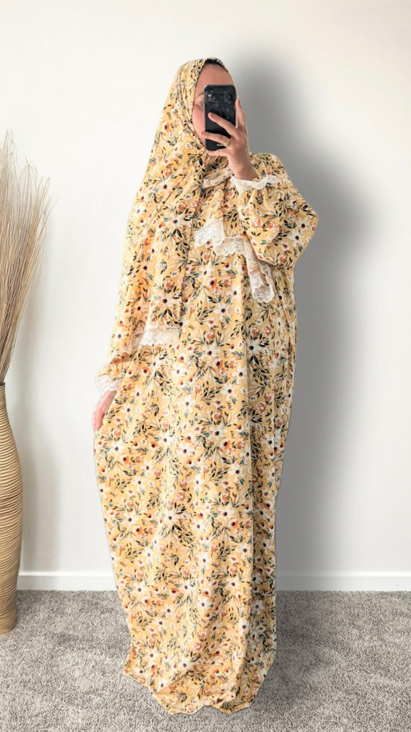 Yellow honey meadow floral print prayer abaya with matching hijab on plain studio background