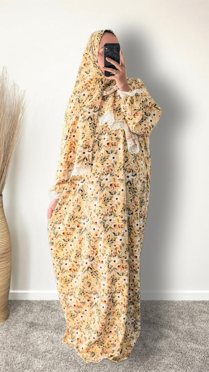 Yellow honey meadow floral print prayer abaya with matching hijab on plain studio background
