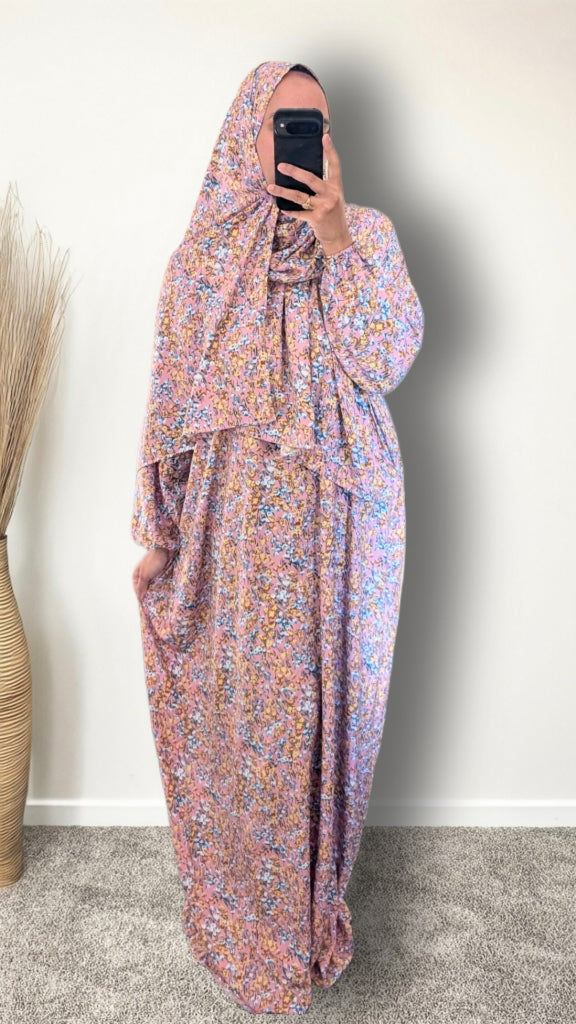 Muslim women wearing Rose Pink ditsy floral print prayer abaya with matching hijab on plain studio background