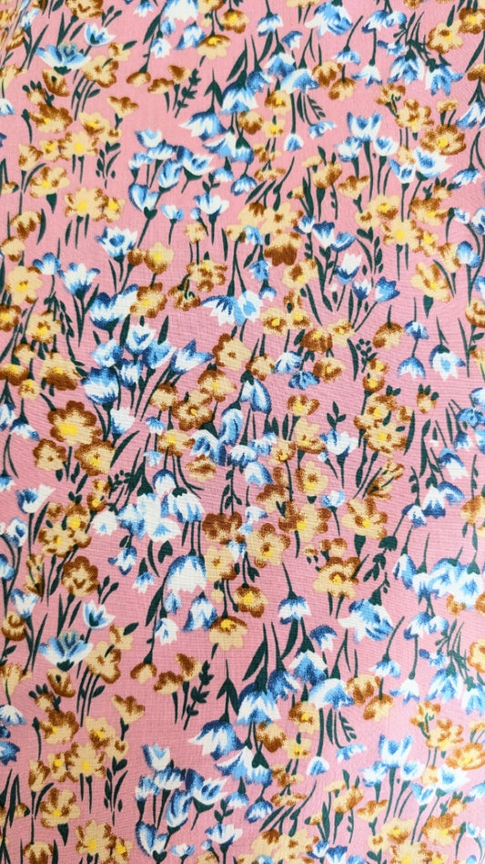 Floral pattern with blue, yellow, and brown flowers on a pink background