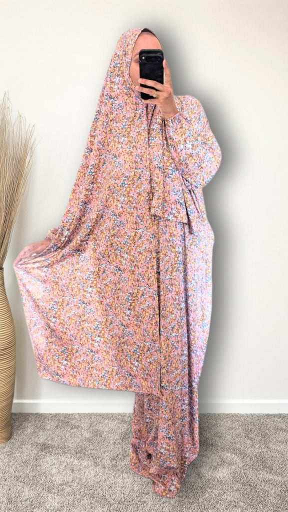 Muslim women wearing Rose Pink ditsy floral print prayer abaya with matching hijab on plain studio background