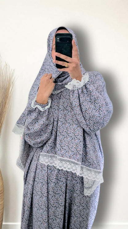 Muslim women wearing sky blue blossom floral  print prayer abaya with matching hijab on plain studio background