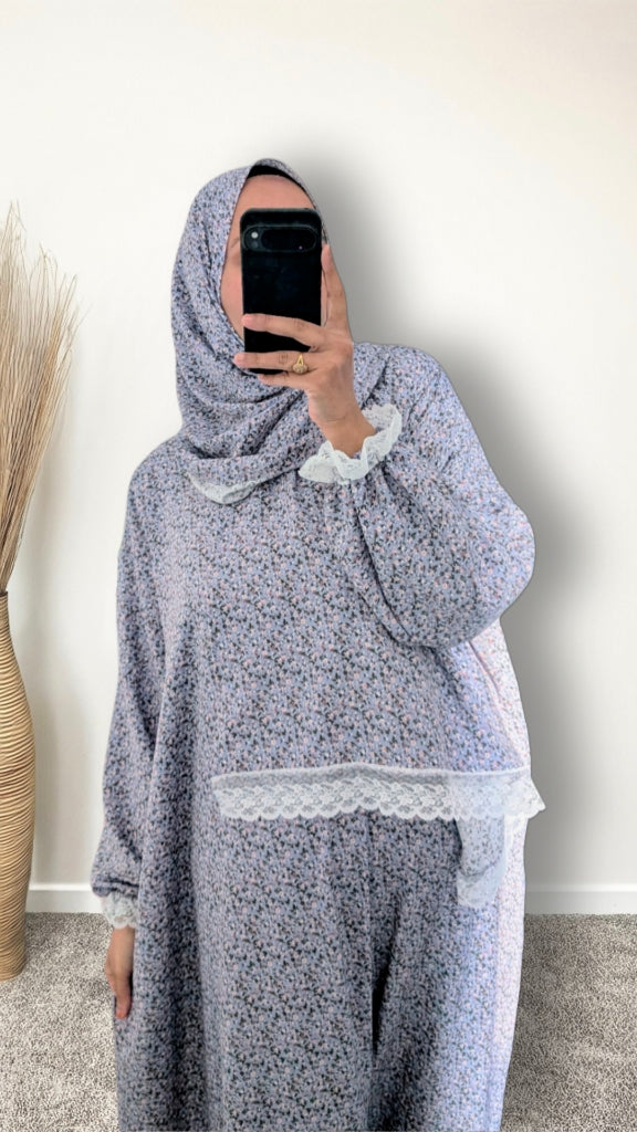 Muslim women wearing sky blue blossom floral  print prayer abaya with matching hijab on plain studio background