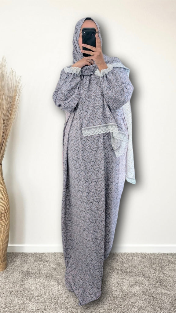 Muslim women wearing sky blue blossom floral  print prayer abaya with matching hijab on plain studio background
