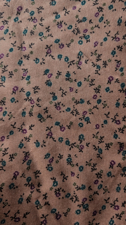 Floral patterned fabric with small flowers  with colours teal and purple on a brown beige background